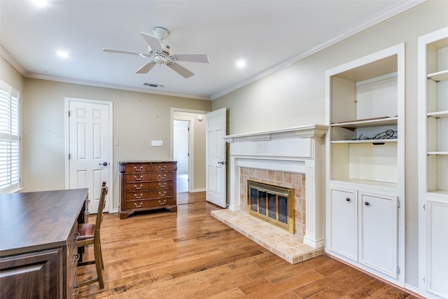 living room with ornamental molding, light hardwood / wood-style floors, and ceiling fan