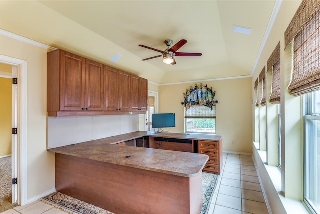 kitchen with ceiling fan, a tray ceiling, kitchen peninsula, and light tile patterned floors