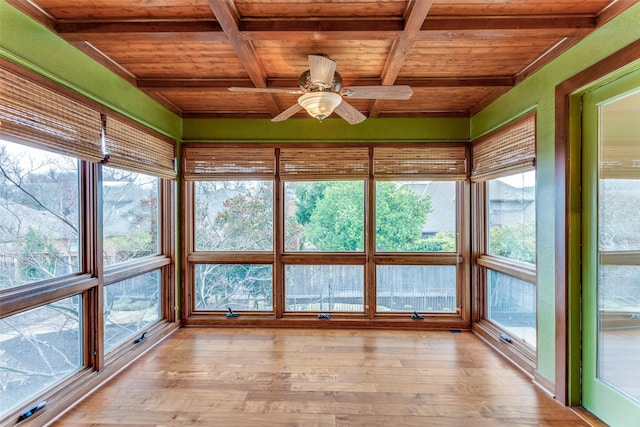 unfurnished sunroom featuring beamed ceiling, coffered ceiling, wooden ceiling, and ceiling fan