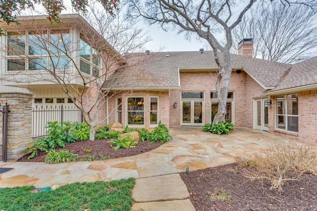 rear view of property with a garage and a patio area