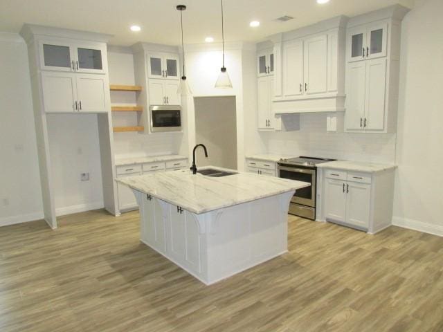 kitchen featuring an island with sink, appliances with stainless steel finishes, sink, and white cabinets