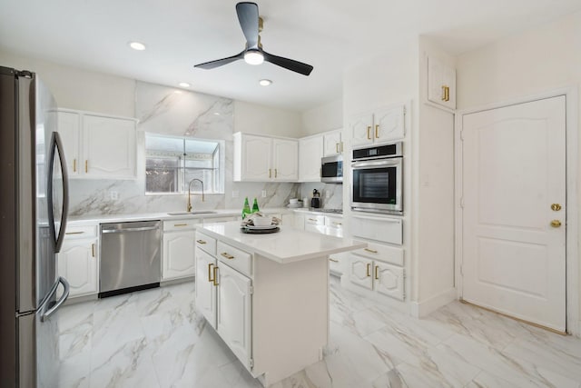 kitchen featuring appliances with stainless steel finishes, sink, white cabinetry, and a kitchen island