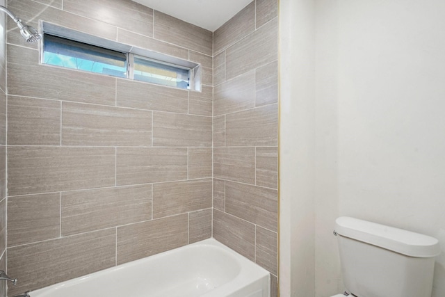 bathroom featuring toilet and tiled shower / bath combo