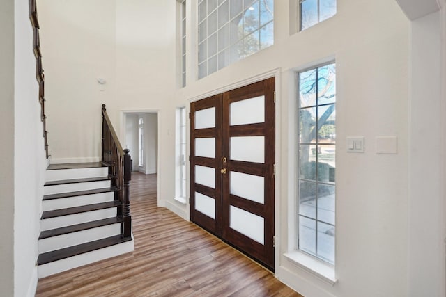 foyer featuring a high ceiling, light hardwood / wood-style flooring, and french doors