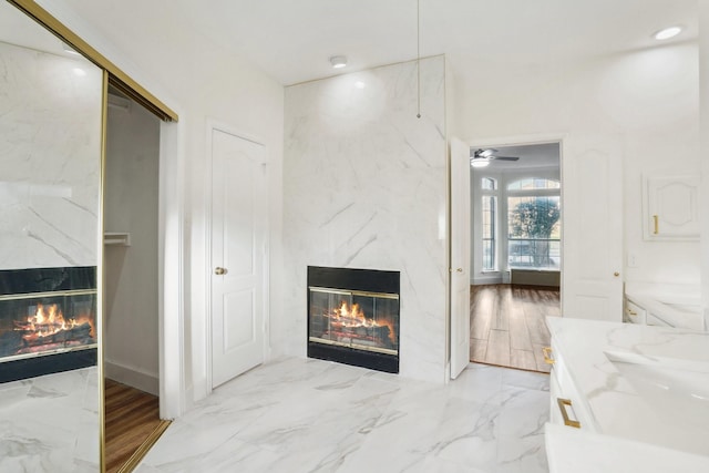 living room with ceiling fan and a premium fireplace