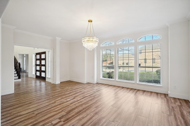 interior space with hardwood / wood-style floors, ornamental molding, and an inviting chandelier