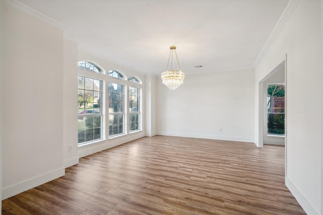 unfurnished dining area with hardwood / wood-style floors, a chandelier, and ornamental molding