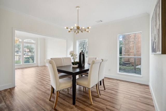 dining room featuring ornamental molding, light hardwood / wood-style floors, plenty of natural light, and a notable chandelier