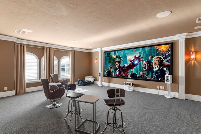 cinema room with carpet floors, a textured ceiling, baseboards, and crown molding