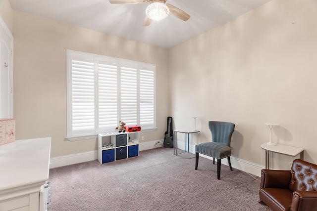 living area with carpet and ceiling fan