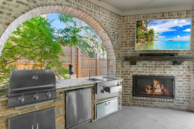 view of patio / terrace with area for grilling, grilling area, and a brick fireplace