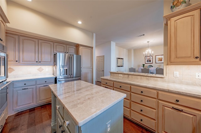 kitchen featuring a kitchen island, decorative light fixtures, backsplash, a chandelier, and high end fridge