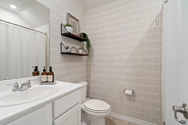 bathroom with tile patterned flooring, vanity, and toilet