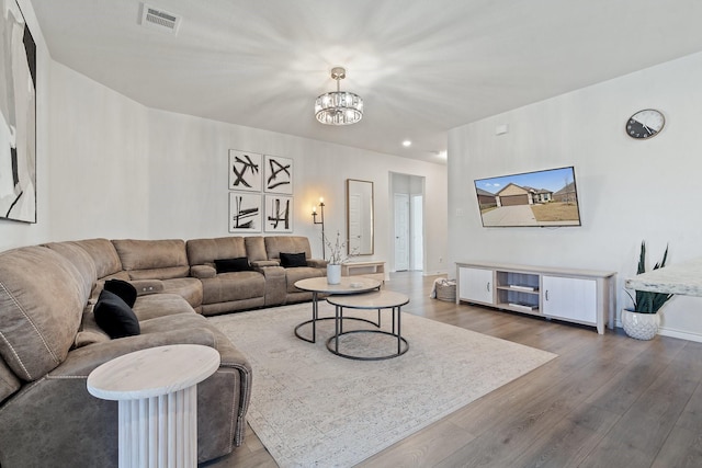 living room with wood-type flooring and a notable chandelier