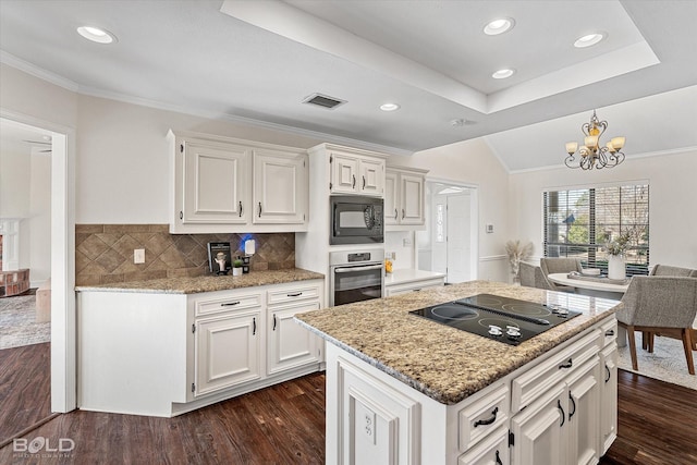 kitchen featuring a tray ceiling, white cabinets, dark hardwood / wood-style flooring, and black appliances