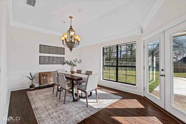 dining space with crown molding, dark hardwood / wood-style floors, a chandelier, and french doors