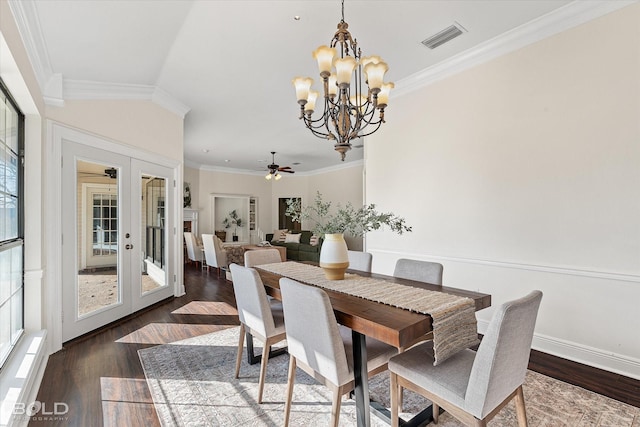 dining room featuring dark hardwood / wood-style floors, ceiling fan with notable chandelier, ornamental molding, and french doors