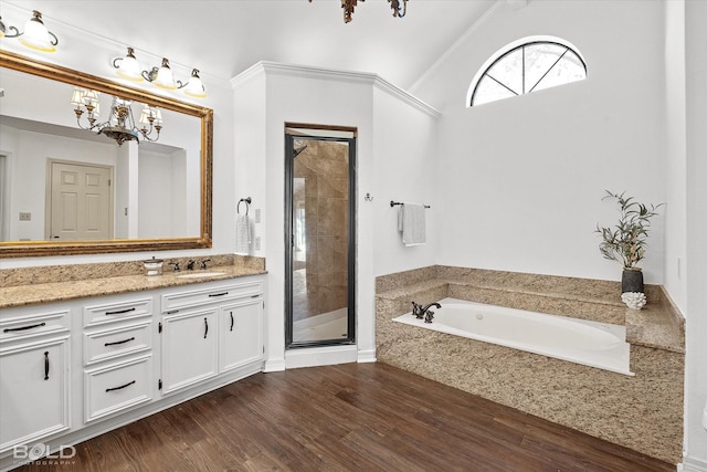 bathroom with lofted ceiling, an inviting chandelier, vanity, plus walk in shower, and hardwood / wood-style floors