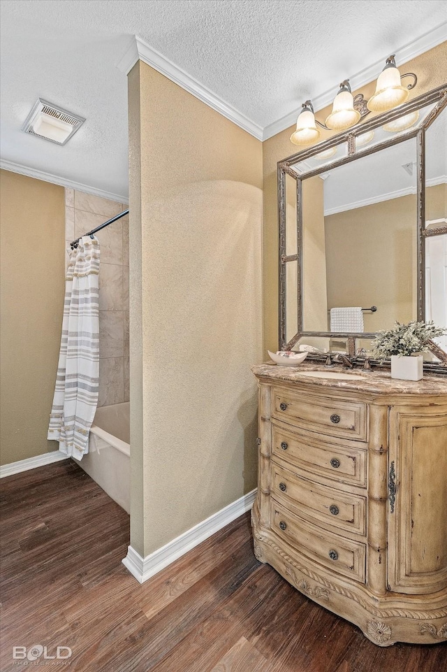 bathroom with crown molding, wood-type flooring, a textured ceiling, and shower / bath combo