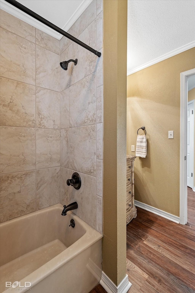 bathroom featuring vanity, tiled shower / bath combo, wood-type flooring, and ornamental molding