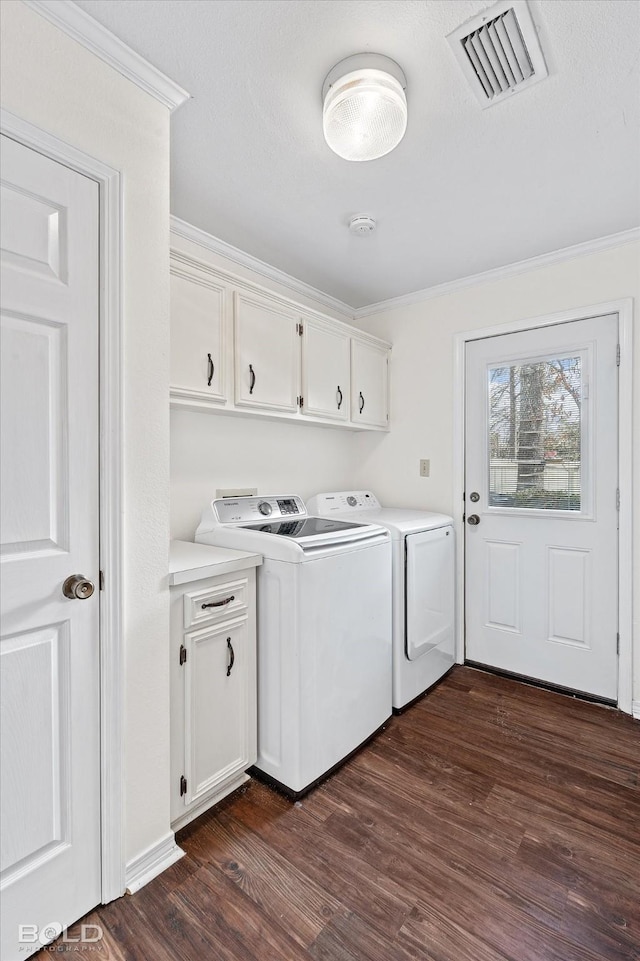 laundry area with cabinets, crown molding, dark hardwood / wood-style floors, and independent washer and dryer