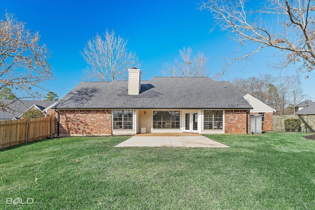 rear view of property with a yard and a patio area