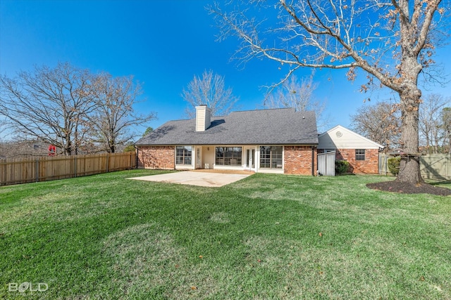 rear view of property with a yard and a patio