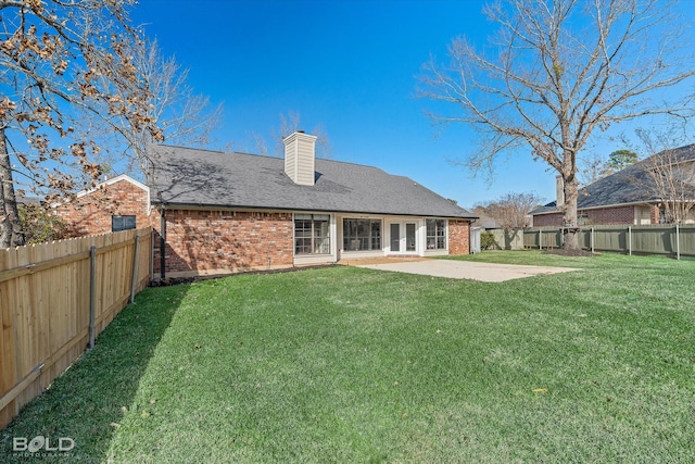 rear view of house with a lawn and a patio area