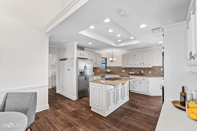 kitchen with a kitchen island, white cabinetry, hanging light fixtures, a tray ceiling, and stainless steel refrigerator with ice dispenser