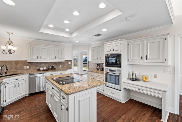 kitchen with decorative light fixtures, sink, white cabinets, black appliances, and a raised ceiling