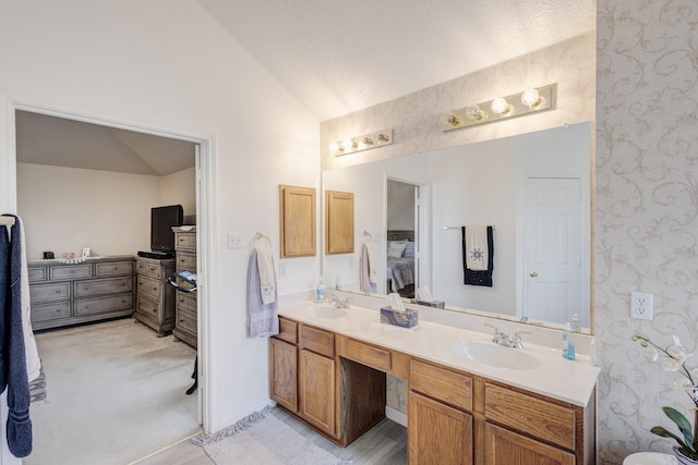 bathroom with hardwood / wood-style flooring, vanity, lofted ceiling, and a textured ceiling