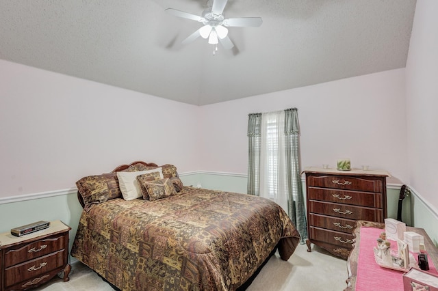 bedroom with vaulted ceiling, ceiling fan, light colored carpet, and a textured ceiling