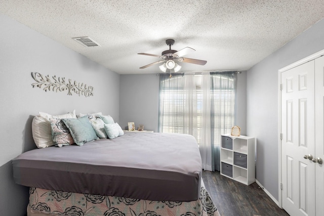 bedroom featuring ceiling fan, dark hardwood / wood-style floors, a textured ceiling, and a closet