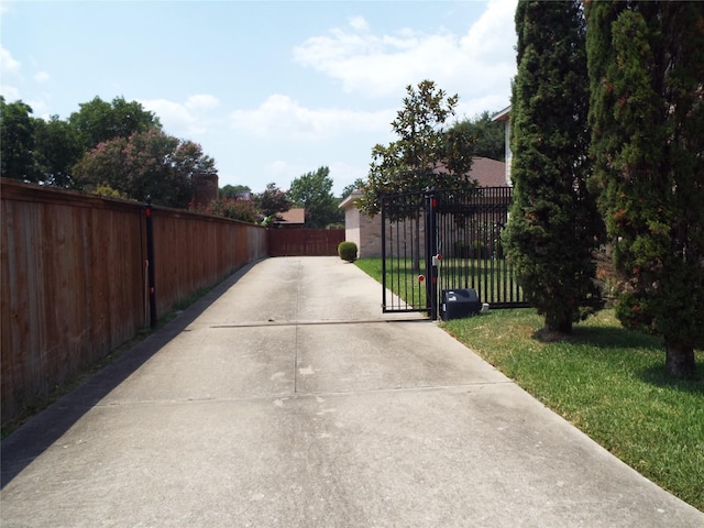 view of gate with a lawn