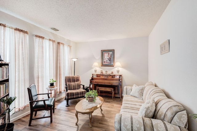 living area featuring a textured ceiling and light hardwood / wood-style flooring