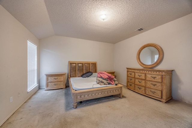 bedroom featuring a textured ceiling, multiple windows, and lofted ceiling