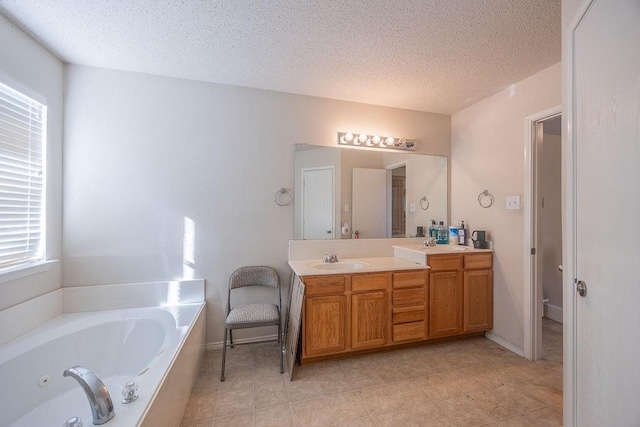 bathroom with a tub to relax in, vanity, and a textured ceiling