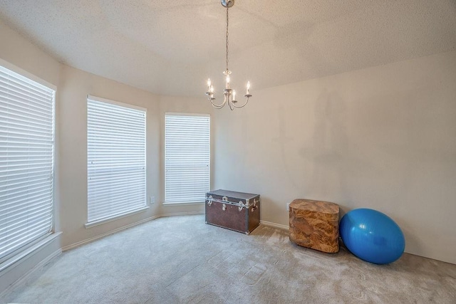 miscellaneous room with light colored carpet, a chandelier, and a textured ceiling