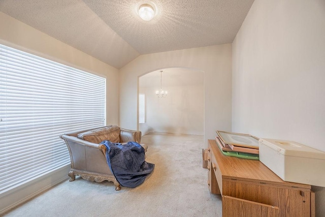 home office featuring vaulted ceiling, carpet floors, a textured ceiling, and a notable chandelier