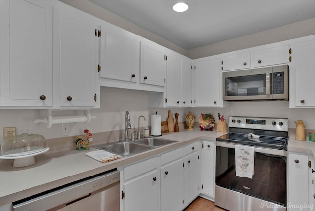 kitchen featuring appliances with stainless steel finishes, sink, and white cabinets