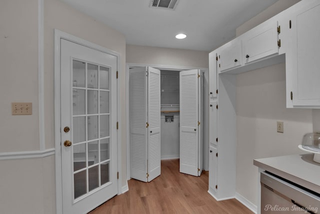 interior space featuring white cabinetry, dishwasher, and light hardwood / wood-style flooring