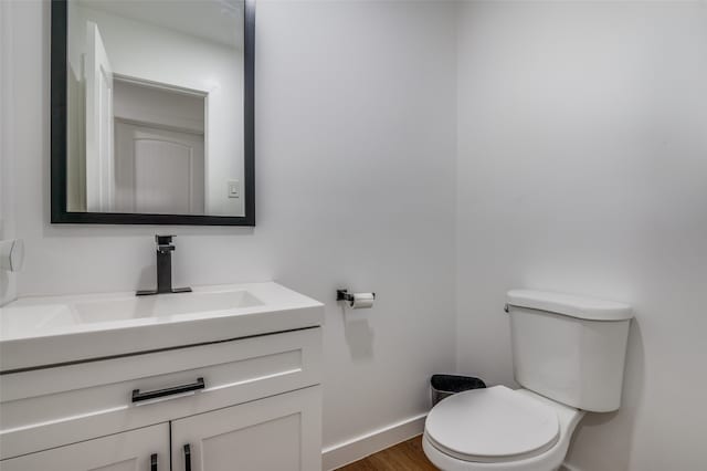 bathroom featuring hardwood / wood-style floors, vanity, and toilet