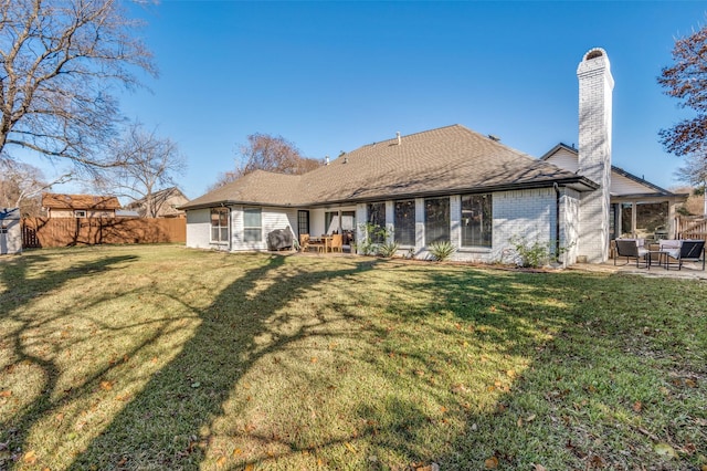 back of house with a yard and a patio