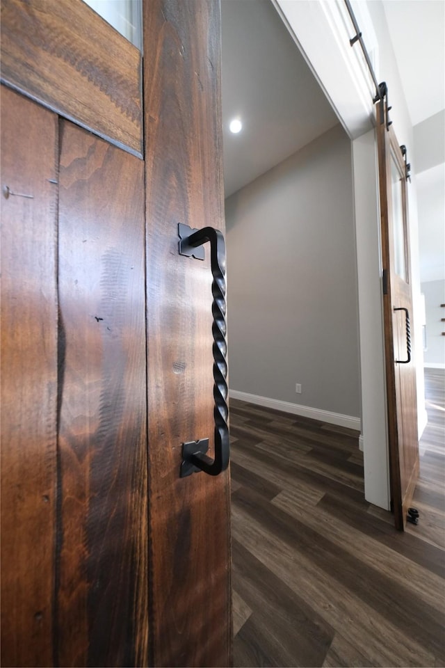 details featuring recessed lighting, a barn door, baseboards, and wood finished floors