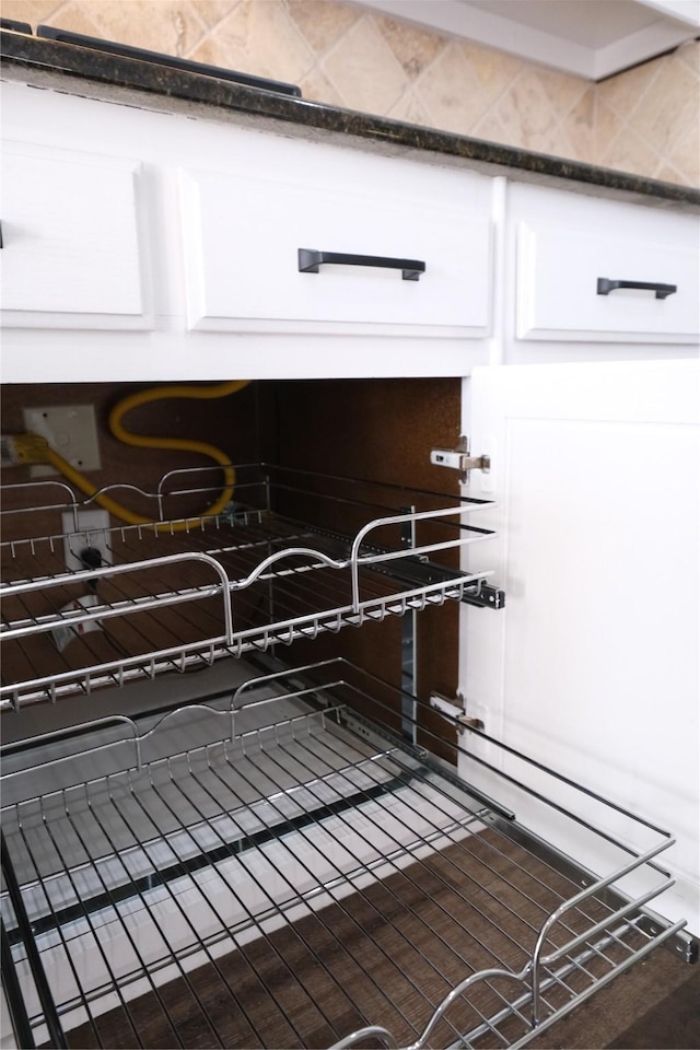 interior details featuring white cabinetry and dark countertops