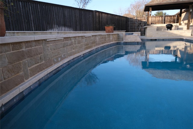 view of swimming pool with a fenced backyard