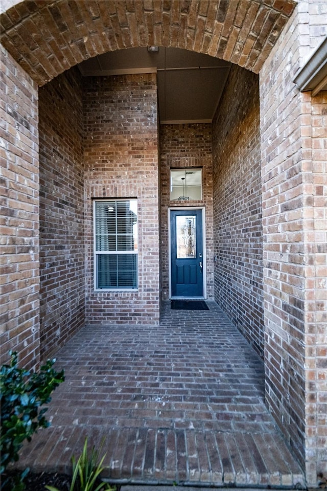 property entrance featuring brick siding