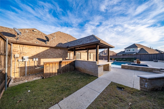 exterior space with a fenced backyard and a pool with connected hot tub