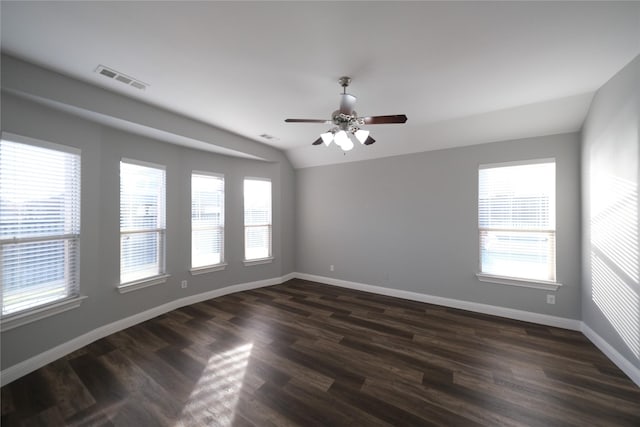 empty room with dark wood finished floors, vaulted ceiling, baseboards, and visible vents