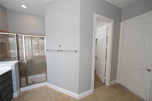 full bathroom featuring a stall shower, vanity, and tile patterned flooring